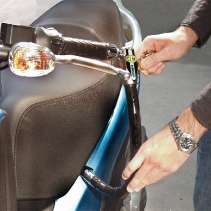 Persona colocando un antirrobo de manillar para evitar robo de moto CLM
